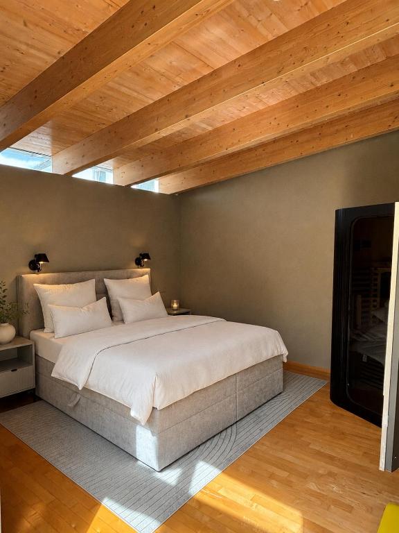 a bedroom with a large bed and a wooden ceiling at PaderCityLoft- lichtdurchflutet und privat mit Kamin-Dachterrasse-Sauna-Außendusche im Atrium in Paderborn
