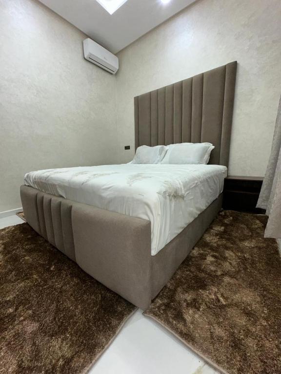 a bedroom with a large bed with a large headboard at Villa ghmate in El Kriet