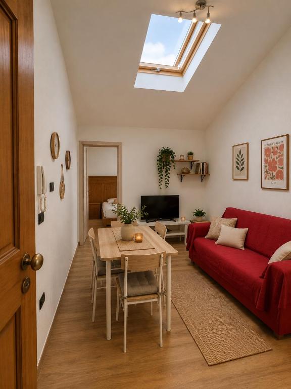 a living room with a red couch and a table at LOFT EMILIA - la tappa perfetta tra Bologna e Ravenna - SELF CHECK-IN in Castel Bolognese