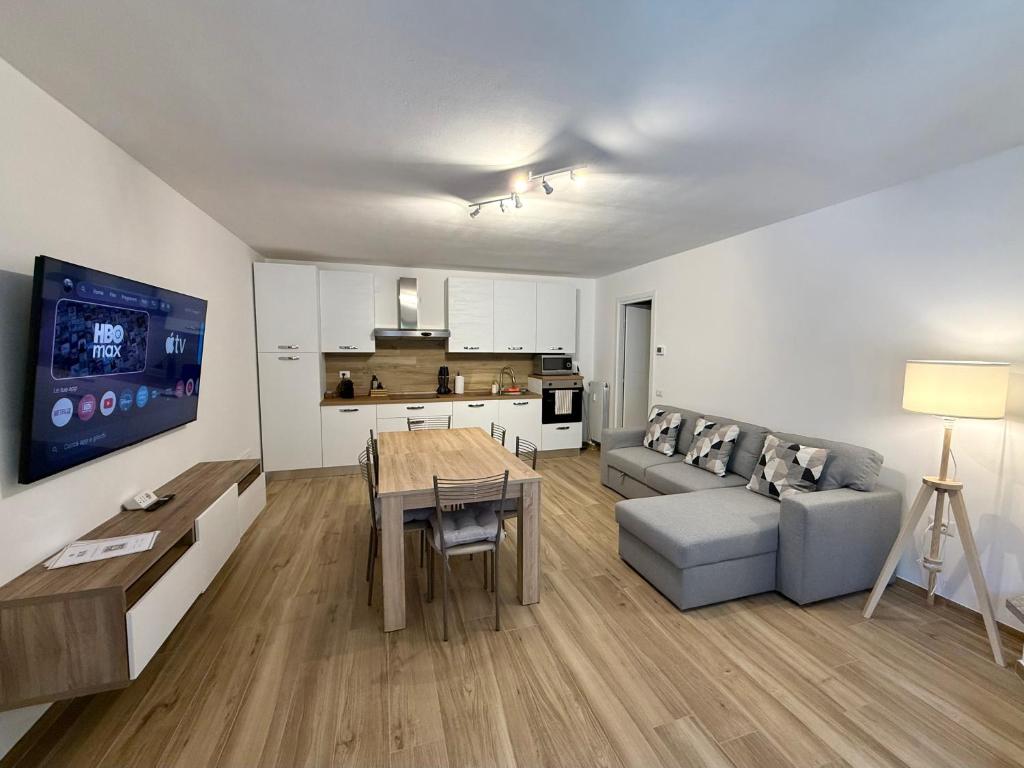 a living room with a couch and a table and a kitchen at Dolce Vetta Valmalenco in Chiesa in Valmalenco