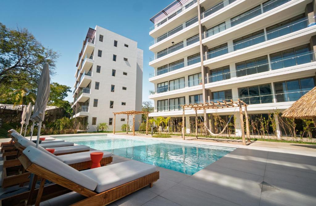 a swimming pool with lounge chairs and a building at Pacific Surfside Ocean Views in Surf City in ChiltiupÃ¡n