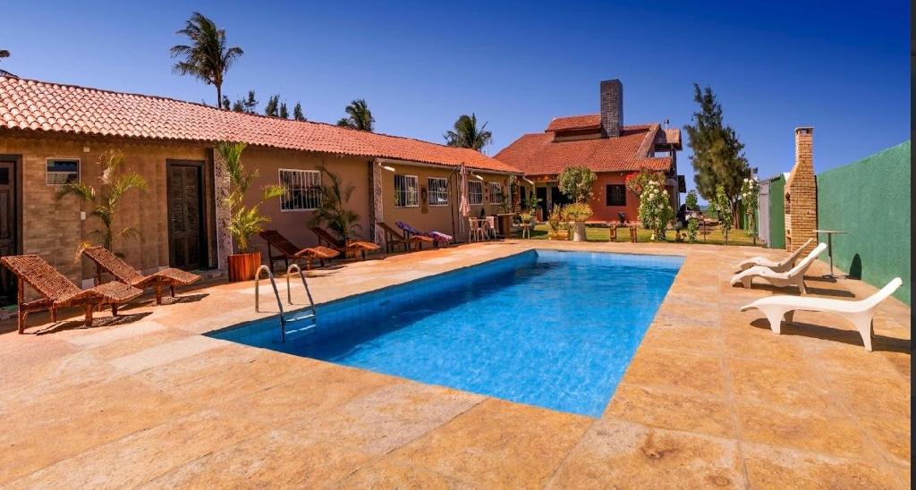 a swimming pool in front of a house at Suítes icarai vila in Caucaia