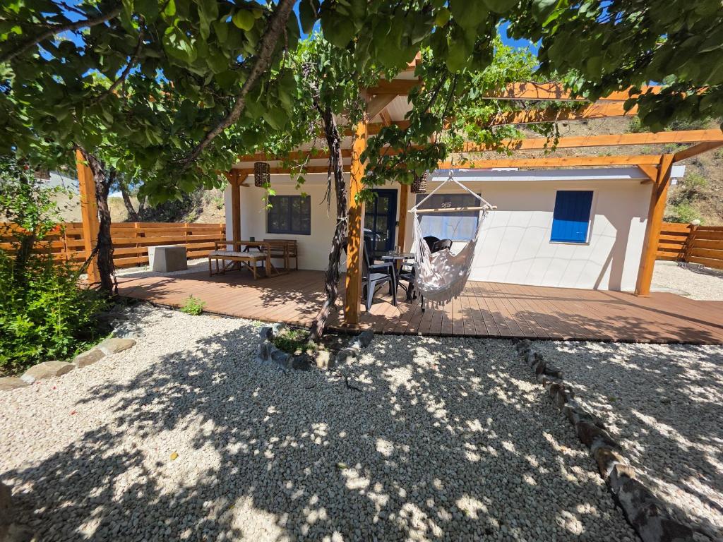 a porch with a swing under a tree at Kellaki Village House in Kellaki