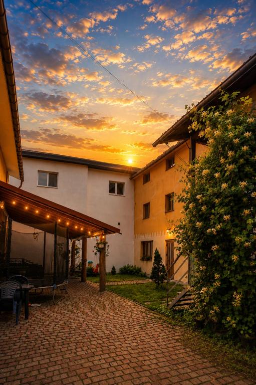 an outdoor patio with a sunset in the background at Guest House Mandrivnyi Rooms&Apartments in Yasinya