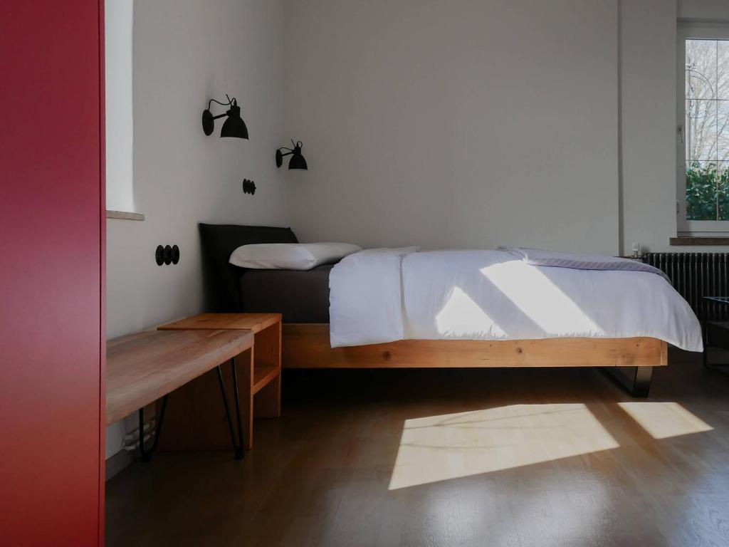 a bedroom with a bed and a table and a window at Das Bauhaus-Eck in Dobritz