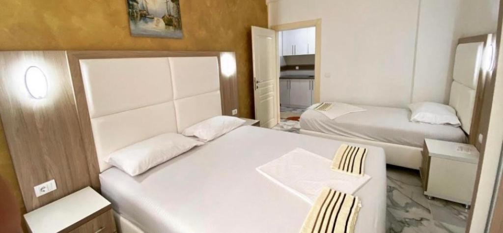 a small room with two beds and a desk at Maxhuri Apartments in Ulcinj