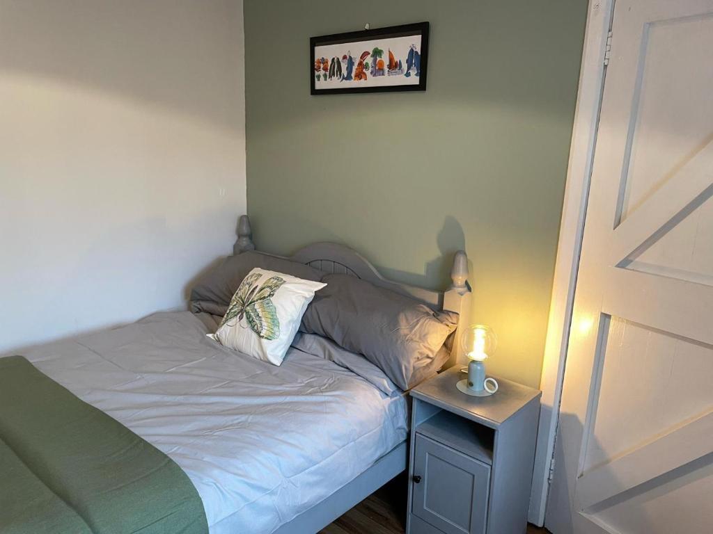 a small bed in a room with a night stand at Butterfly cottage in Belmullet