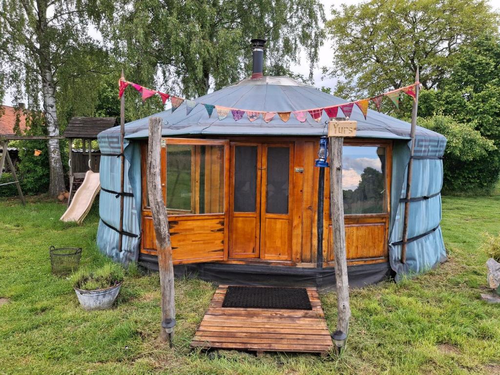 a yurt in a yard with a wooden porch at YURs in Baexem
