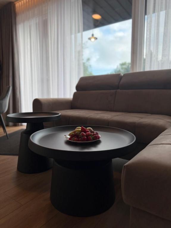 a table with a plate of fruit on it in a living room at Sea Spray Nida in Nida