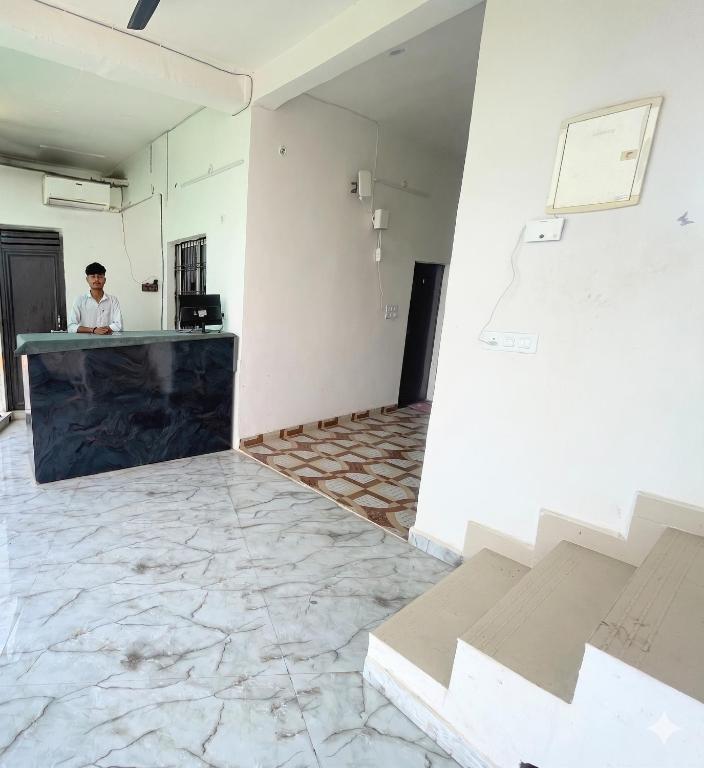 a man standing at a counter in a room at Hotel bhagwati palace in Orchha