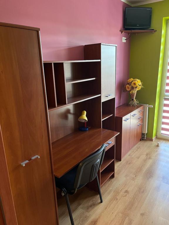 ein Zimmer mit einem Holzschreibtisch und einem Stuhl in der Unterkunft Arkadiusz in Tarnobrzeg