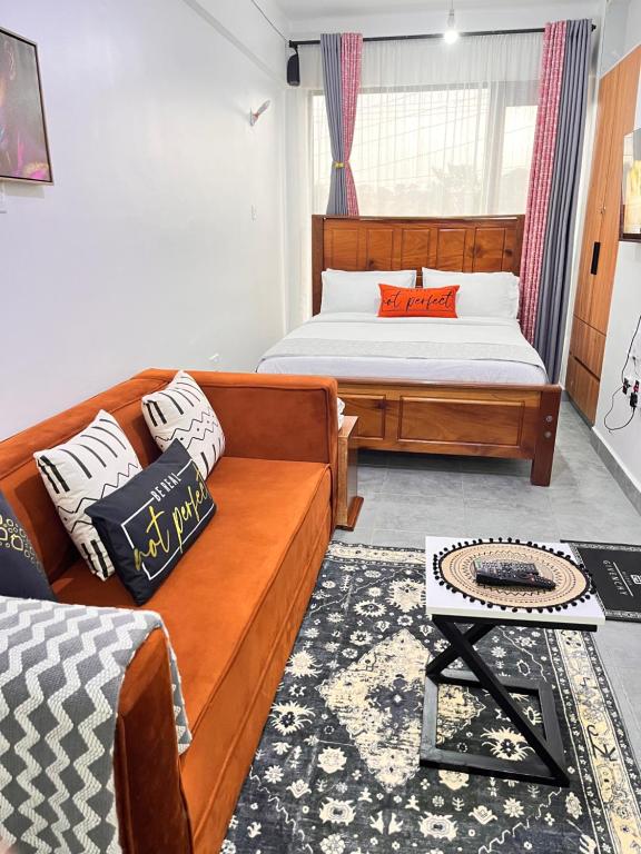 a living room with a couch and a bed at Casa Stays in Kiambu