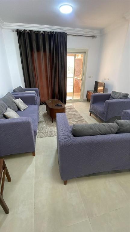 a living room with two couches and a table at Maqsad 24 in Kafr ash Sharā‘inah
