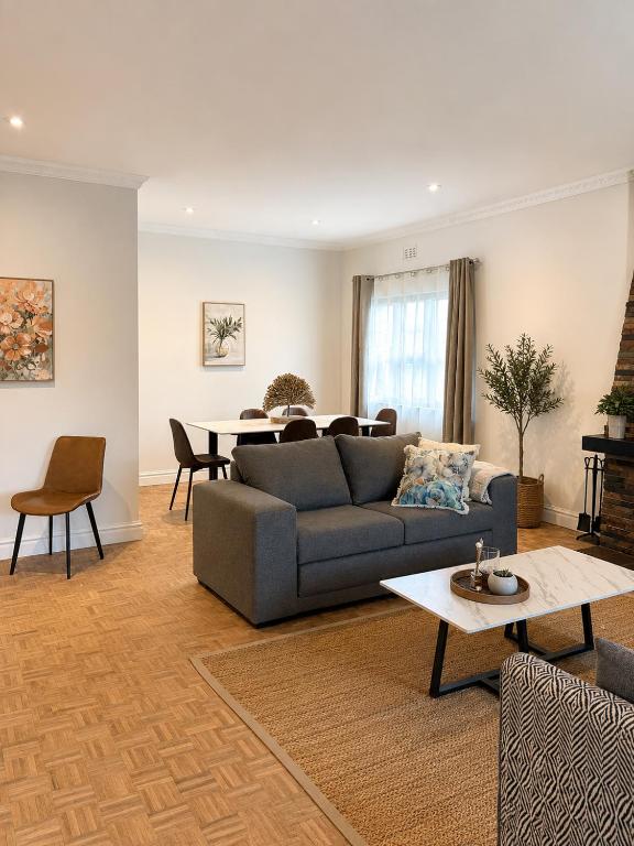 a living room with a couch and a table at Stirling House in Mooiriver