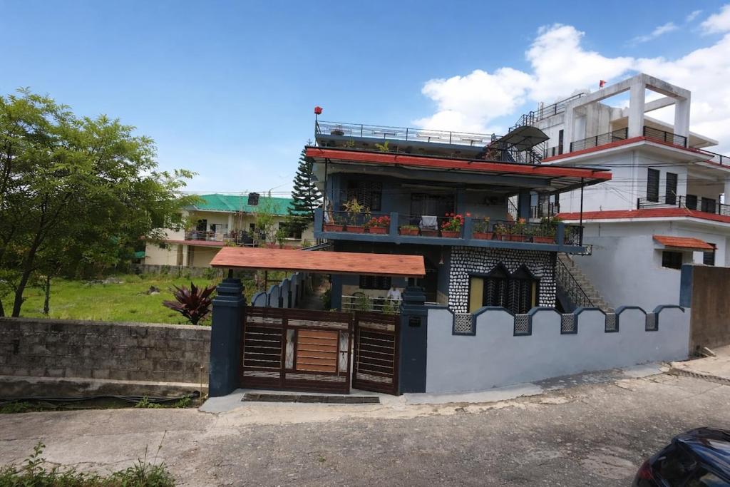 a building with a balcony with flowers on it at Mona's Villa Homestay in Dharmsāla