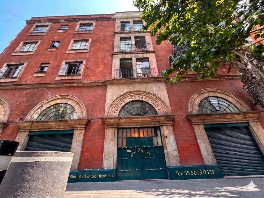 an old red brick building with a green door at Singular Centro Histórico in Mexico City