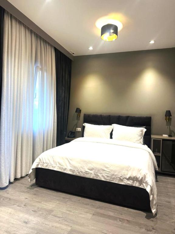 a bedroom with a large bed and a window at Hotel EIBA in Peshkopi