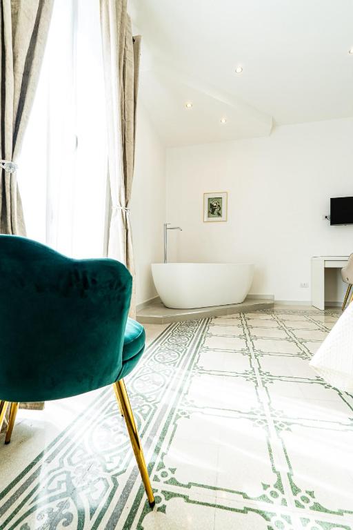 a bathroom with a tub and a chair at Palazzo Sorge - Sicilian Charm in Balestrate