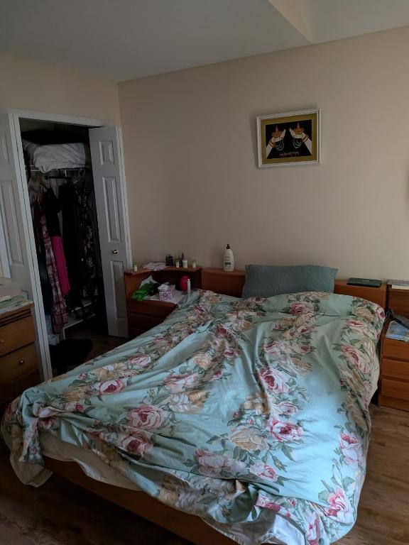 a bedroom with a bed with a floral comforter at Masonville Guesthouse in London