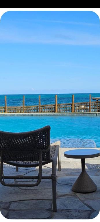 a table and a bench next to a pool at Nomar 208 pe na areia na Praia dos carneiros in Tamandaré