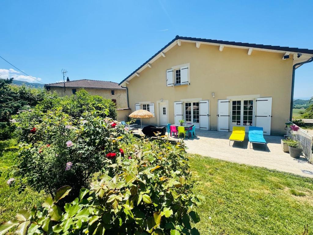 a house with a yard with colorful furniture and flowers at Les Terrasses du Vercors in Beauregard-Baret