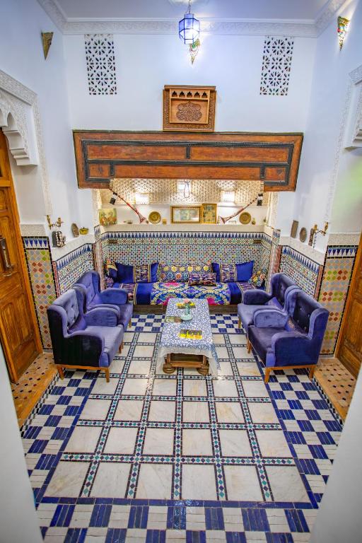 a living room with blue couches and a table at Riad Mozaik Fes in Fez
