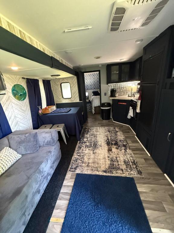 an rv living room with a couch and a kitchen at Hidden Anchor in Burton
