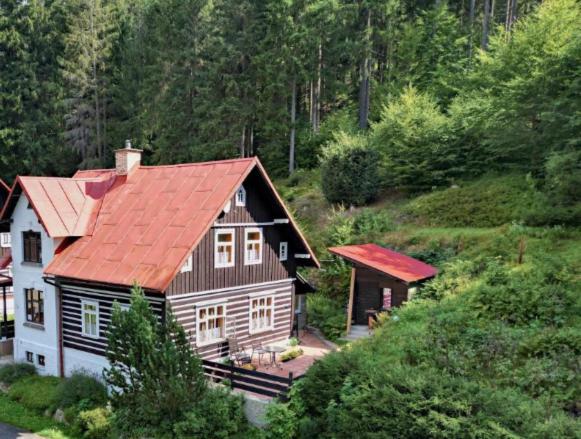 a house with a red roof in a forest at Chata Štefička in Josefŭv Dŭl
