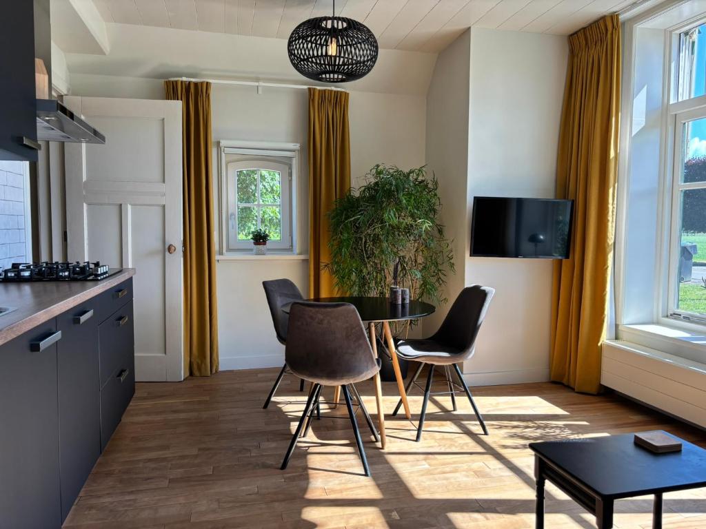 a kitchen and dining room with a table and chairs at Recreatieappartement BoerdeRijlst - De Winkel in Sint Nicolaasga