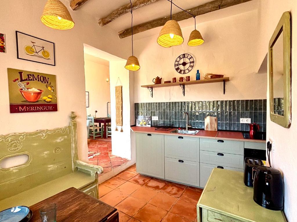 a kitchen with white cabinets and a table at Casa Amigos Sorvilan - Limón in Sorvilán