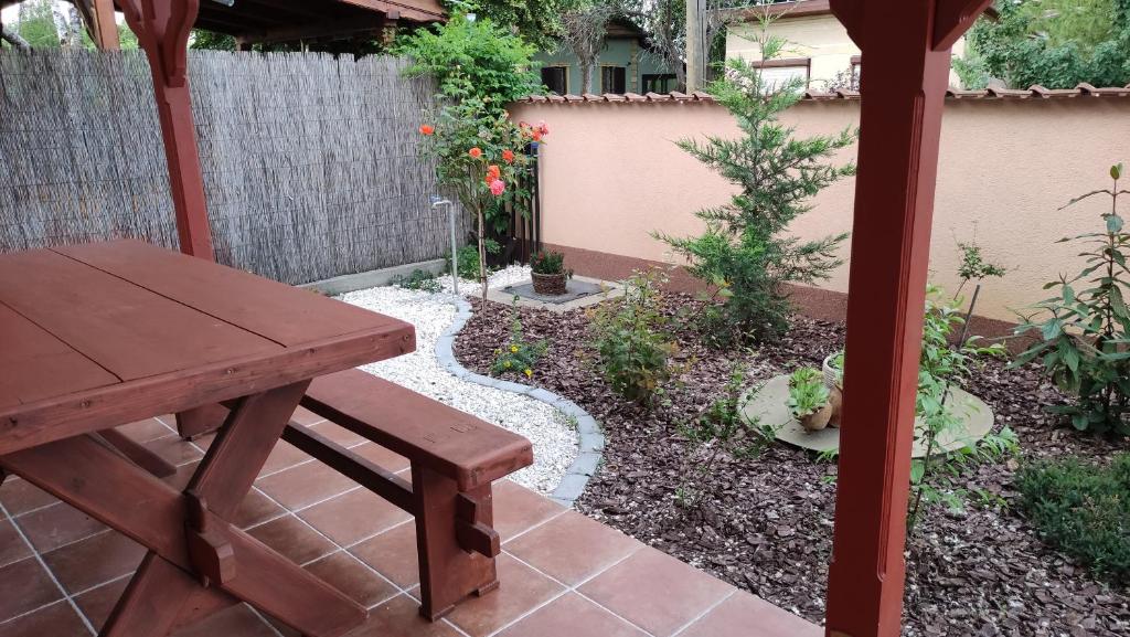 a garden with a picnic table and a fence at Napsugár Nyaraló in Tiszaalpár