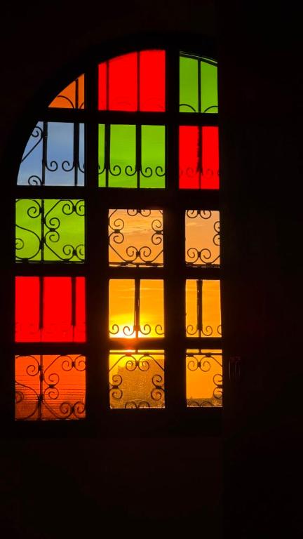 a multicolored window in a room with a view at HoneyPath Ocean Retreat in Tamraght Ouzdar