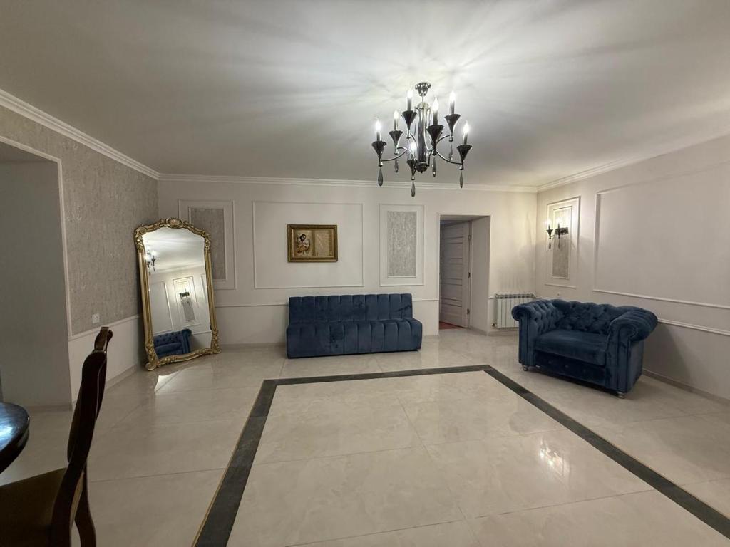 a living room with blue furniture and a mirror at Tevosyan Gold EVN Airport in Pʼarakʼar