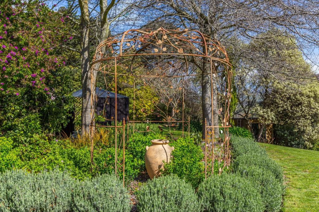 a gazebo in the middle of a garden at Bellbird Guest Accommodation in Akaroa