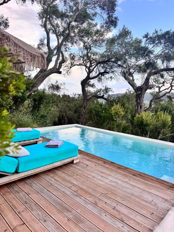 a pool with blue lounge chairs on a wooden deck at Lucié in Argyrátika