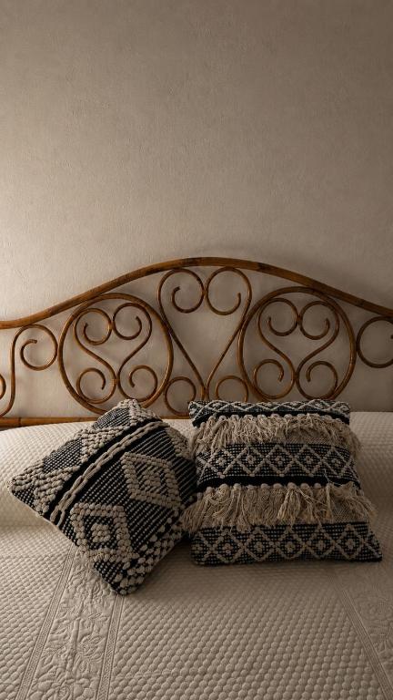 ein Bett mit einem Metallkopfteil und zwei Kissen darauf in der Unterkunft Arkea in Trapani