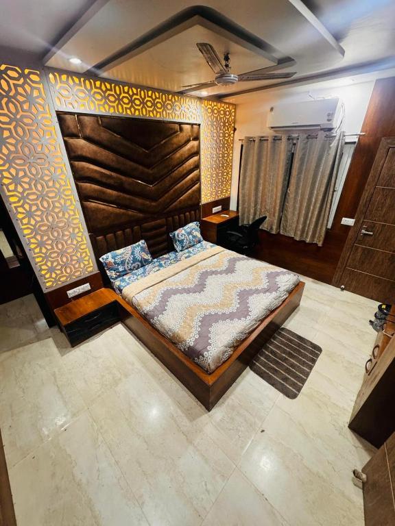 a bedroom with a large bed with a wooden headboard at shyam hotel rexa in Vrindāvan