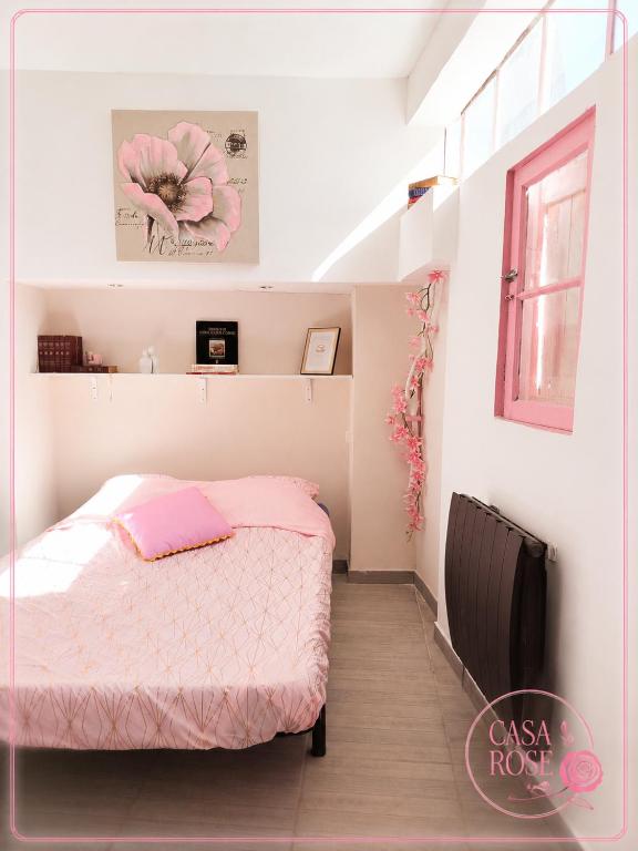 a small bedroom with a pink bed and a window at Casa Rose, Petit cocon avec jardin dans un quartier calme de Toulon in Toulon