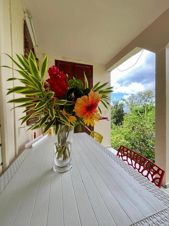 a vase of flowers sitting on a table at Corossole in Bouillante