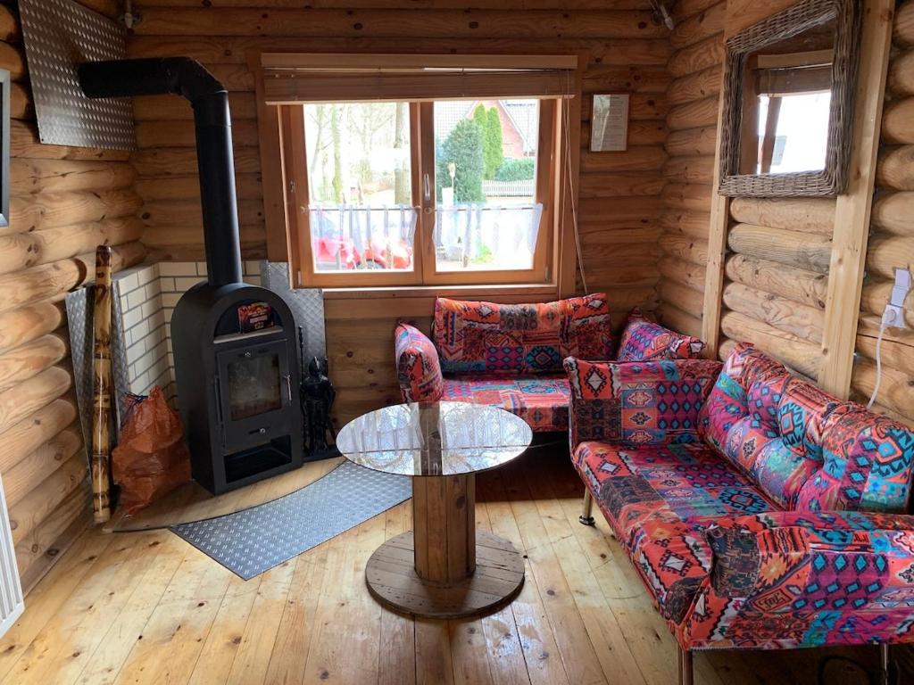 a living room with a stove in a log cabin at Vacations for a good cause in Drochtersen