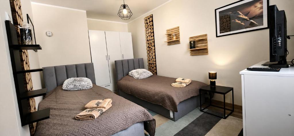 a room with two beds and a television in it at RosalieRose Cozy Corner in Radom