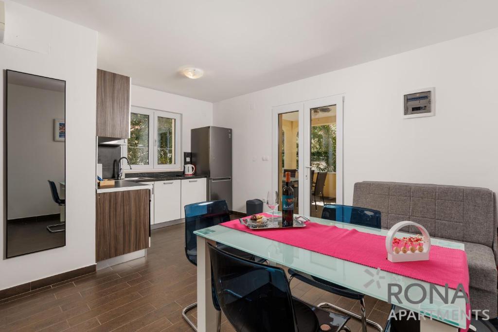 a kitchen and living room with a table and chairs at Rona Apartments Zlatko in Šimuni