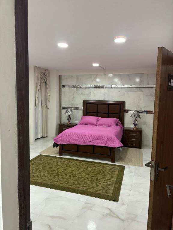 a bedroom with a bed with a pink blanket at Garsol in Oruro