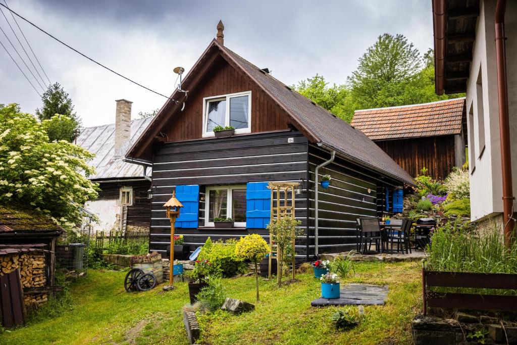 a small black house with a brown roof at Valašská chalupa Červenka in Lužná