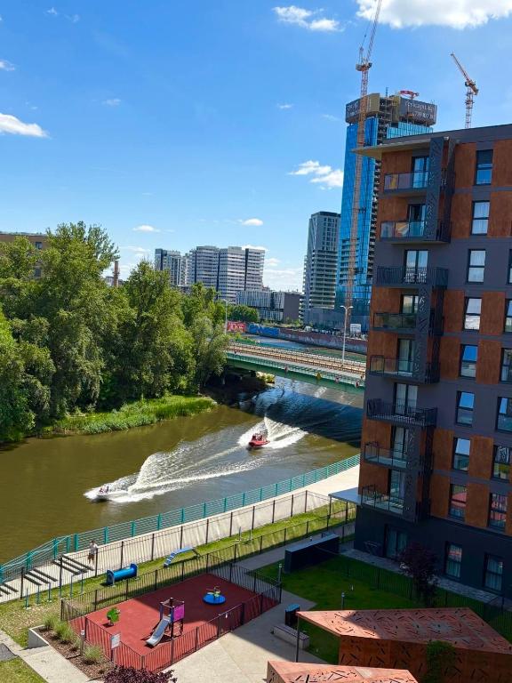 a view of a river with a boat in it at Jesionowe Apartamenty Ashwood Apartments Widok na Odrę 1,4 km od Rynku Parking Podziemny w Cenie Klimatyzacja Sauna w 1 Apt River Oder view 1,4 km Market Square Underground parking Balcony Air conditioning in Wrocław