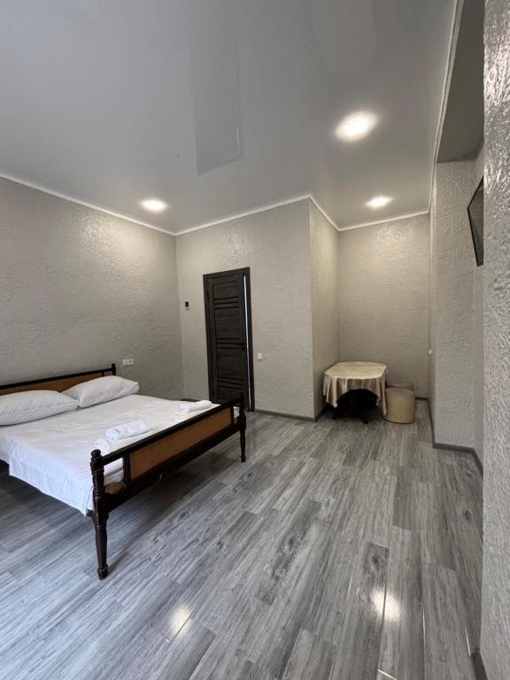 an empty room with a bed and a table at Abelyans Fam Hotel in Alaverdi