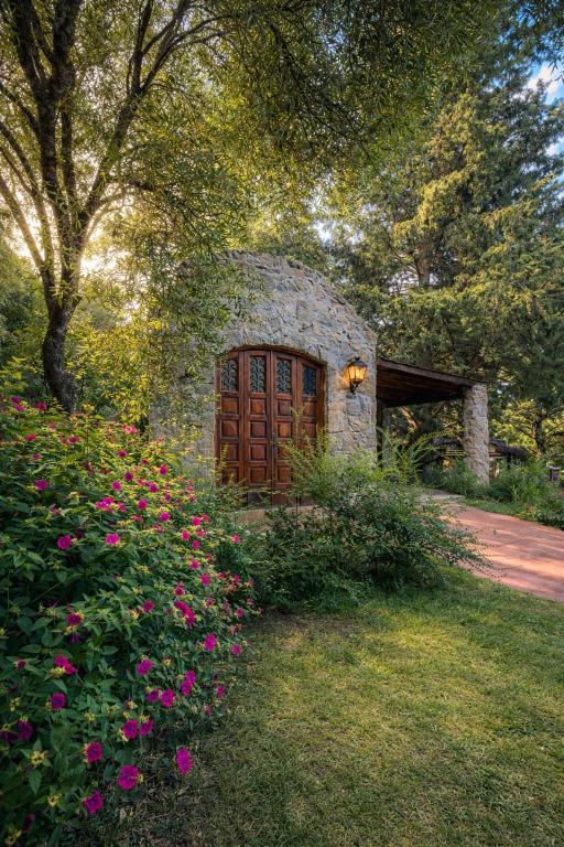 a stone building with a wooden door in a field of flowers at Casita de Piedra B&B in Villa del Dique