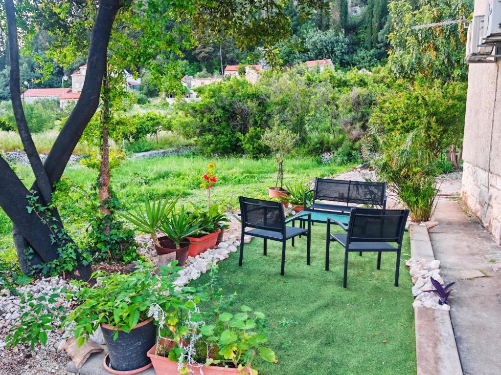 a garden with a table and chairs and plants at 150m to Beach - Free Parking - Garden View in Slano