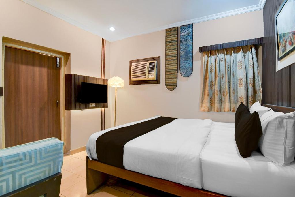 a bedroom with a large white bed and a television at Collection O Lake Mall Kalighat Formerly Venkateshwara in Kolkata