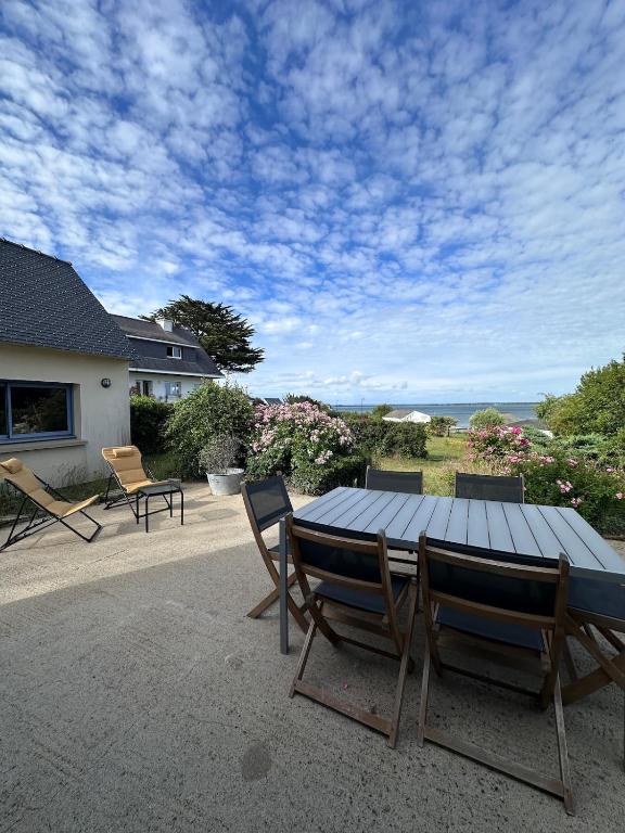a wooden table and chairs on a patio at La Petite Maison Bénance in Sarzeau